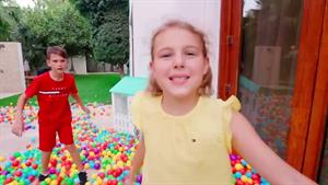 پنج کودک وانمود می‌کنند با توپ‌های توپ رنگی می‌بارند